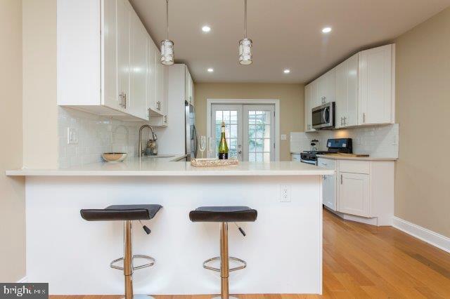 2026 McClellan Street Philadelphia, PA 19145 - Photo 9 of 32 a kitchen with stainless steel appliances a sink cabinets and wooden floor