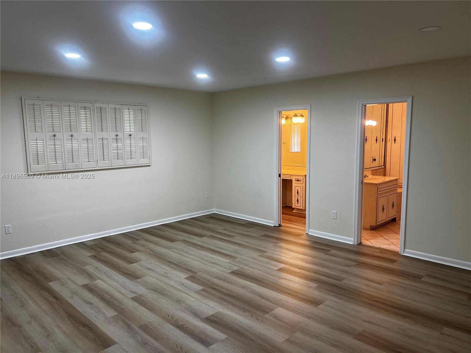 7751 Southwest 131st Street Pinecrest, FL 33156 - Photo 11 of 23 an empty room with wooden floor and windows