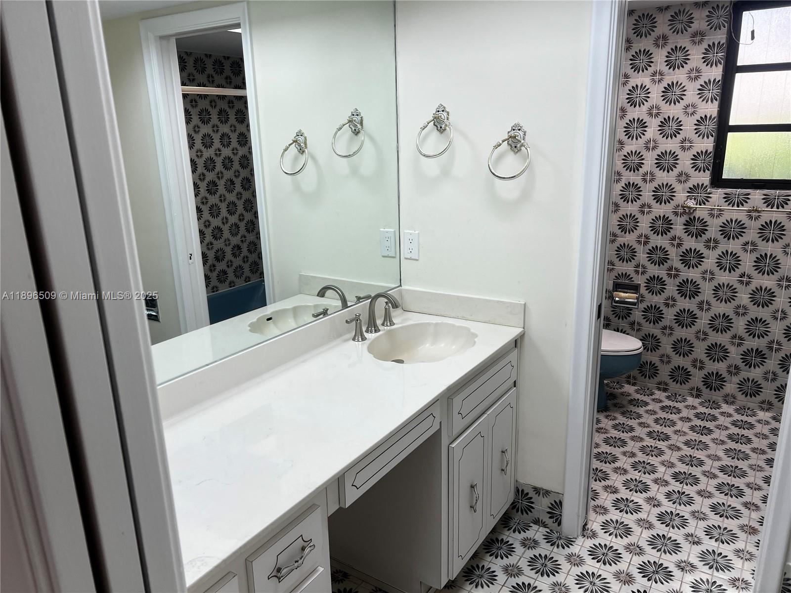 7751 Southwest 131st Street Pinecrest, FL 33156 - Photo 18 of 23 a bathroom with a sink a vanity and a mirror