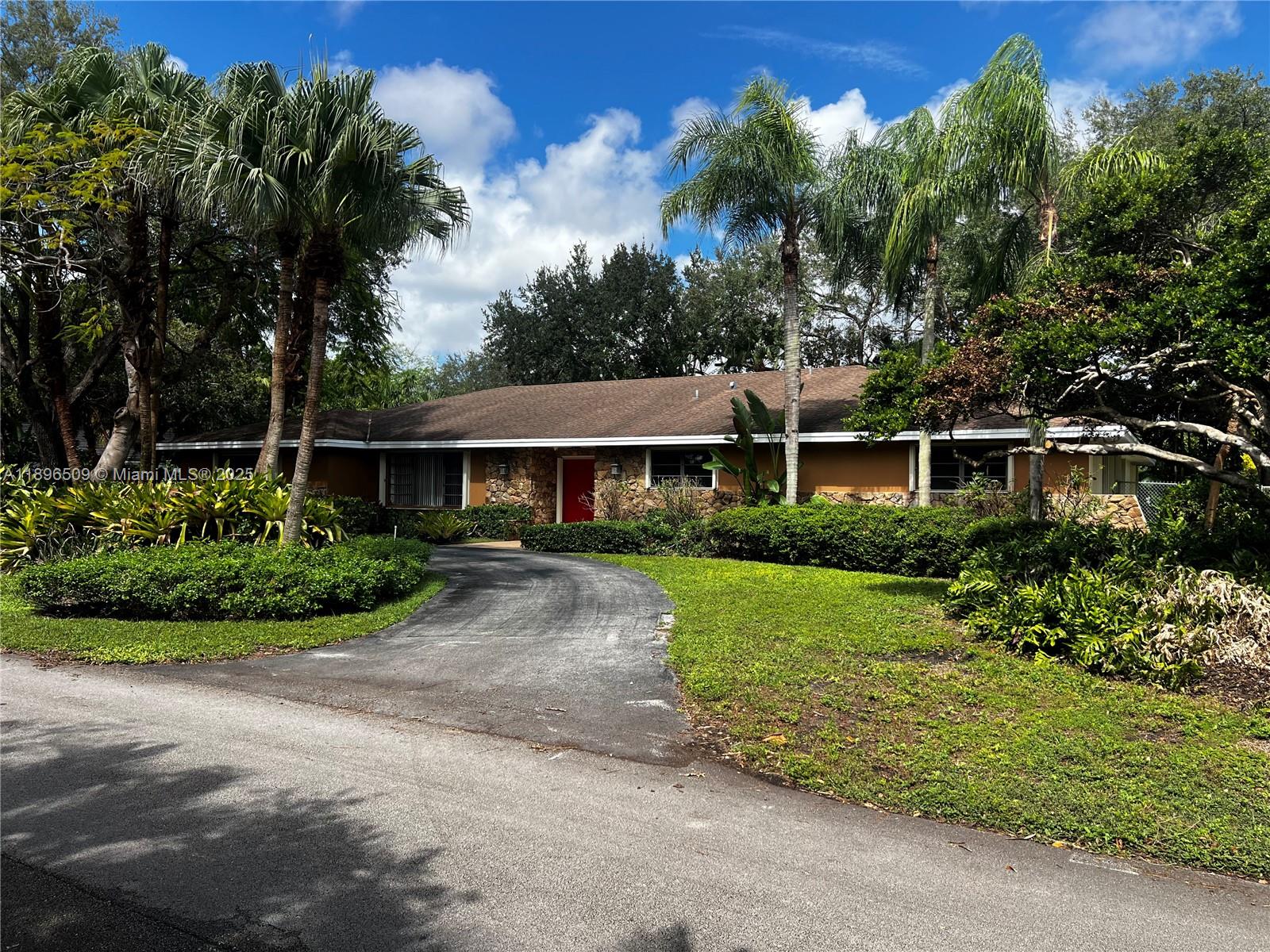 7751 Southwest 131st Street Pinecrest, FL 33156 - Photo 2 of 23 a front view of a house with a garden