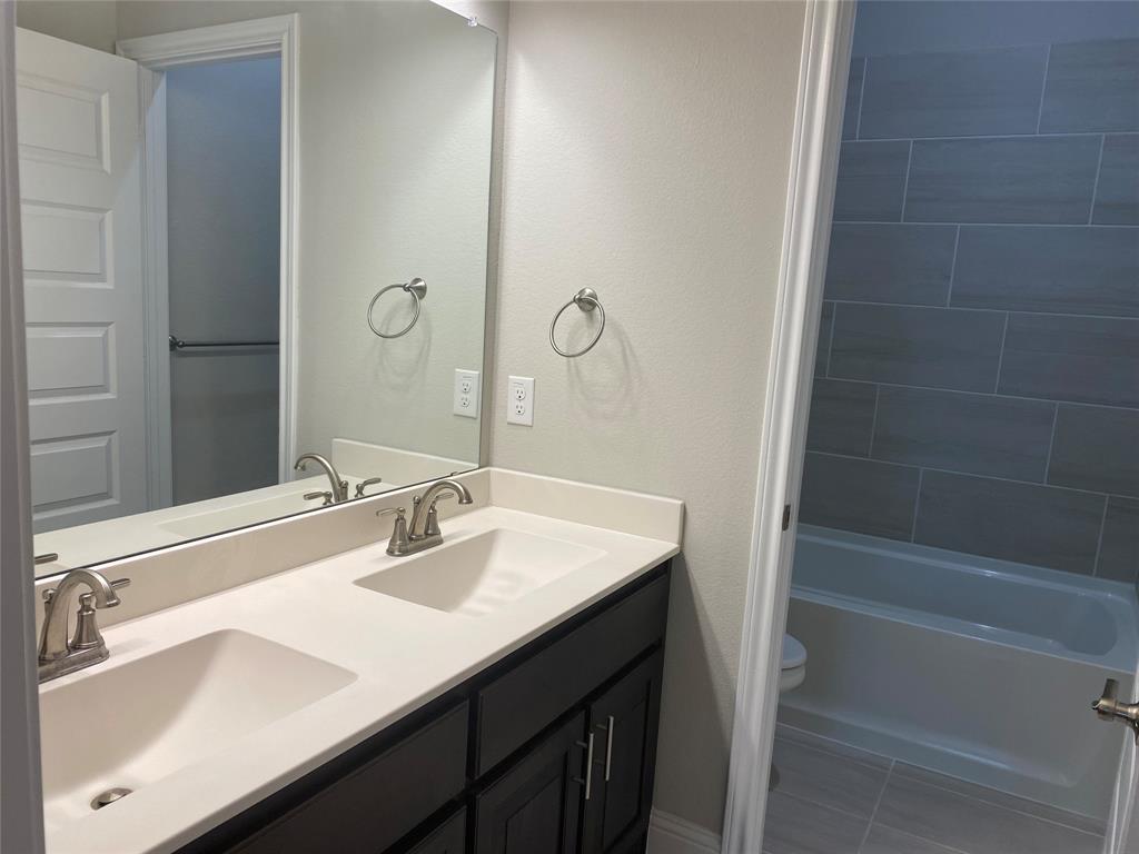 209 Johnson Street Granbury, TX 76048 - Photo 35 of 40 Full bathroom with toilet, double vanity, shower combination, and tile flooring