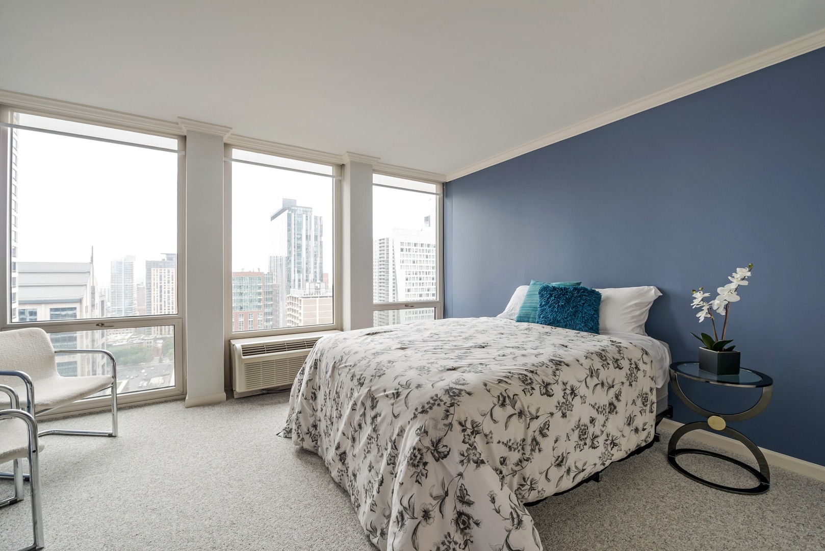 111 East Chestnut Street, Unit 29K Chicago, IL 60611 - Photo 8 of 10 a bedroom with a bed patio table and a large window