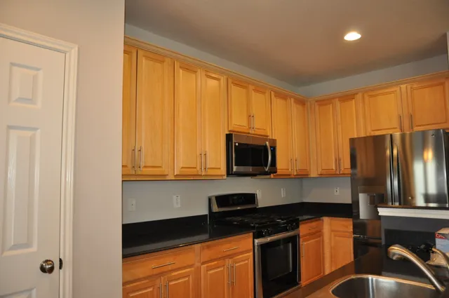 a kitchen with stainless steel appliances granite countertop a stove top oven a sink and dishwasher