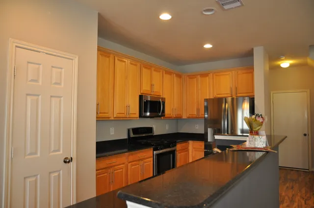 a kitchen with stainless steel appliances granite countertop a stove and a refrigerator