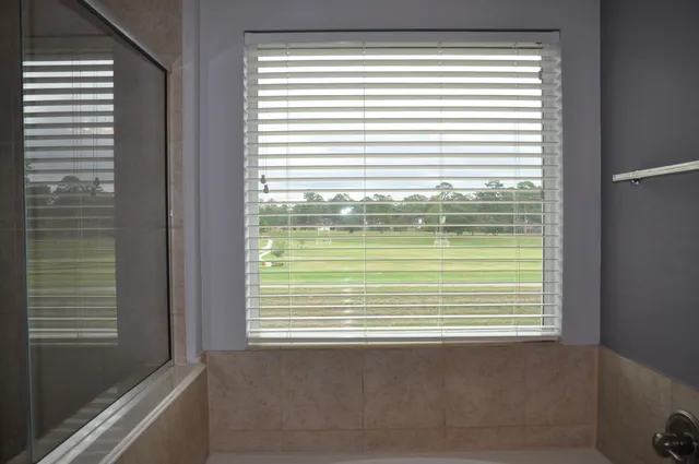 a bathroom with a sink a bathtub and next to a window