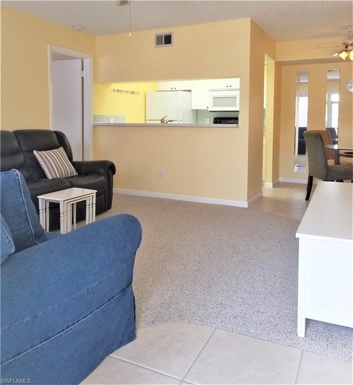 4363 27th Court Southwest, Unit 2103 Naples, FL 34116 - Photo 1 of 15 a living room with a couch and a table