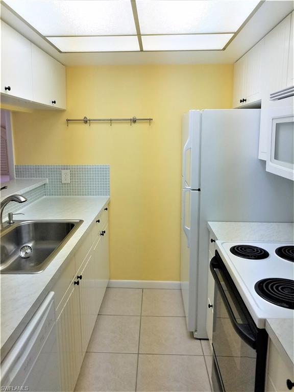 4363 27th Court Southwest, Unit 2103 Naples, FL 34116 - Photo 6 of 15 a kitchen with a sink a stove and a refrigerator