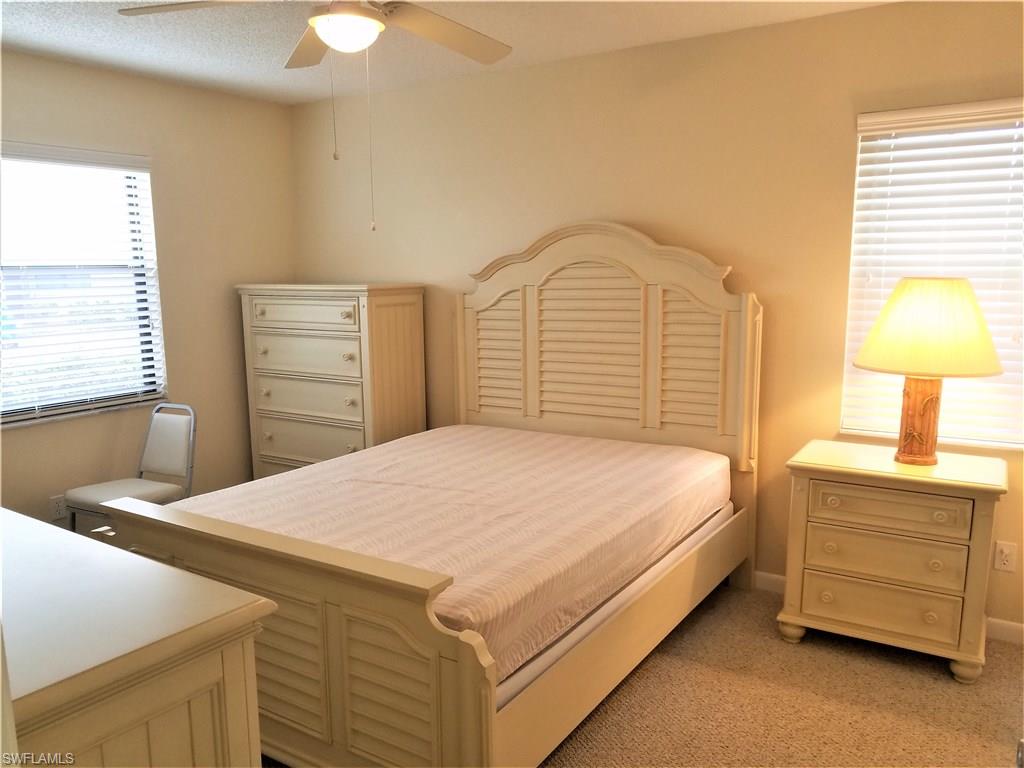 4363 27th Court Southwest, Unit 2103 Naples, FL 34116 - Photo 9 of 15 a bedroom with a bed and a dresser