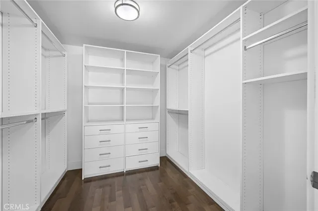 a view of walk in closet with empty racks