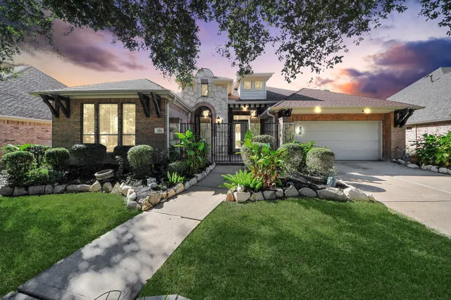 a front view of a house with a yard and glass windows