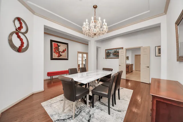 a view of a dining room with furniture a chandelier and wooden floor