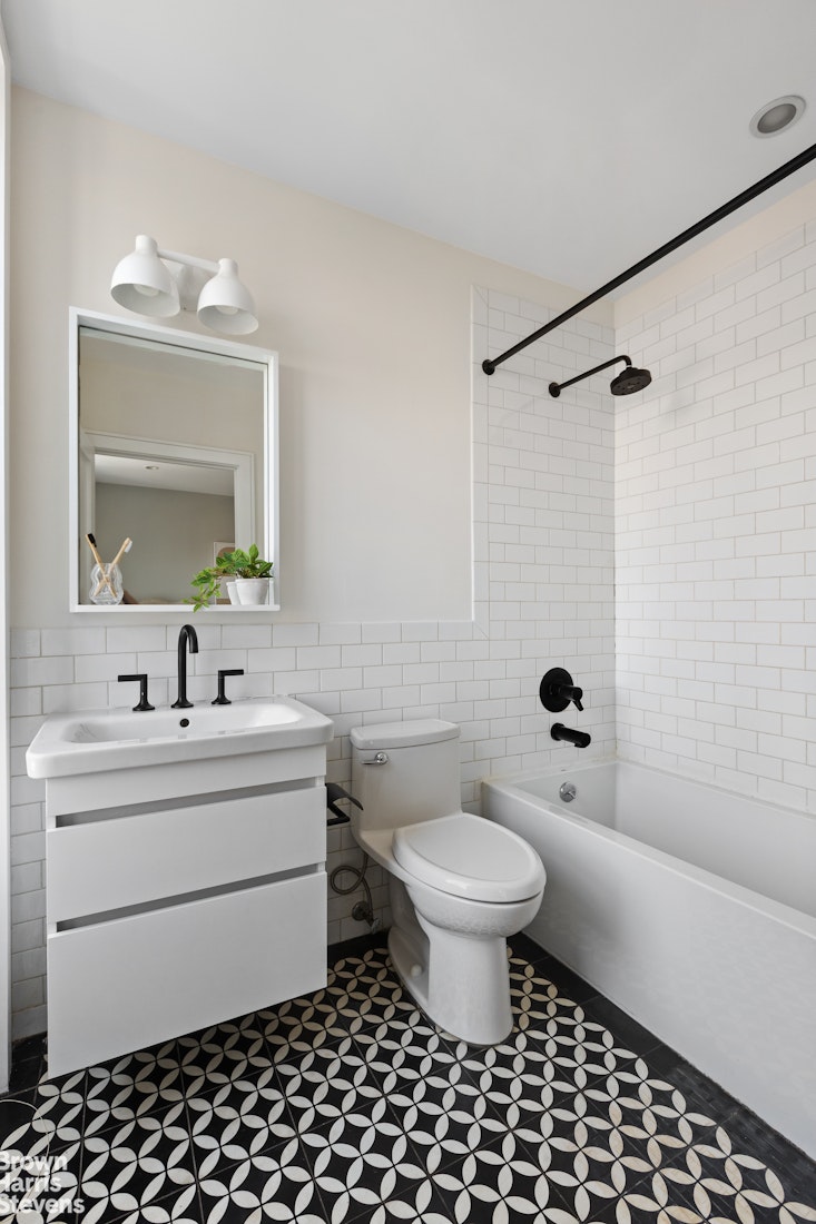 210 Macon Street Brooklyn, NY 11216 - Photo 10 of 13 a bathroom with a sink a toilet a mirror and shower