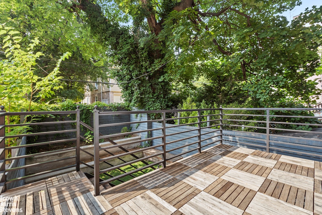 210 Macon Street Brooklyn, NY 11216 - Photo 5 of 13 a view of backyard with wooden floor and fence