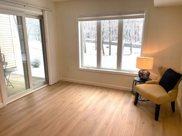 a view of a room with wooden floor and lounge chair