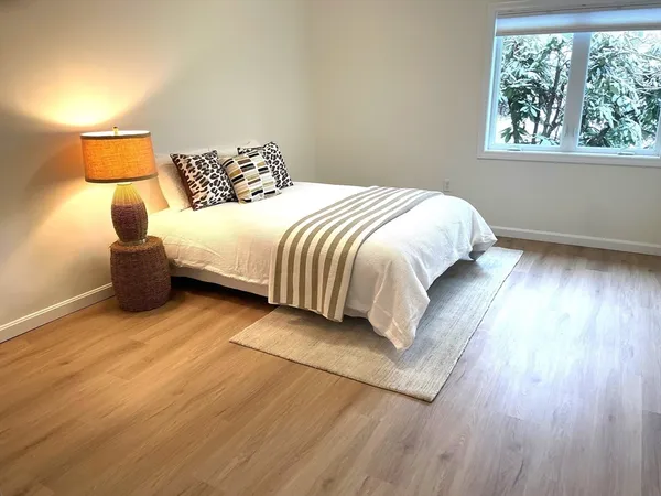 a large bed sitting in a bedroom next to a window