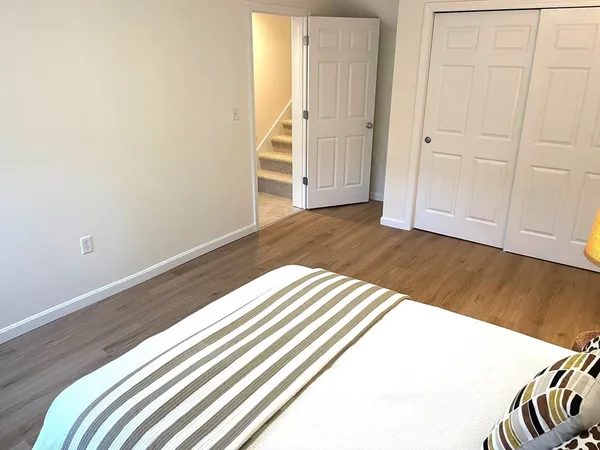 a view of a bedroom with wooden floor