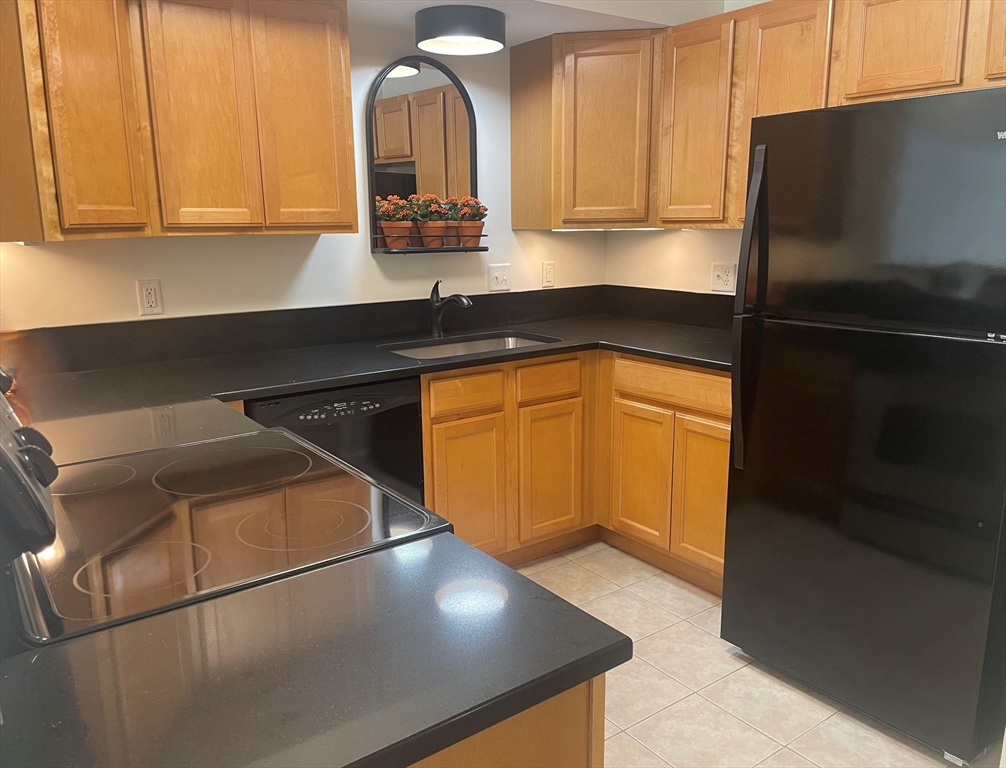 2 Duck Pond Road, Unit 108 Beverly, MA 01915 - Photo 4 of 17 a kitchen with stainless steel appliances a sink cabinets and a refrigerator