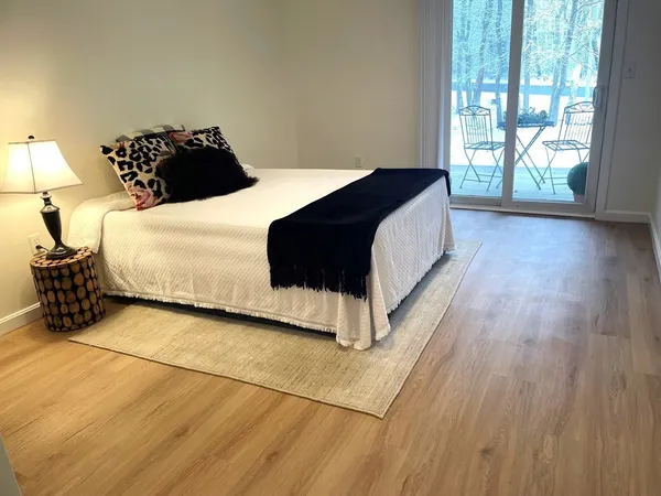 a bedroom with a bed lamp and a large window