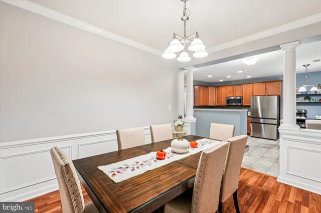 a view of a dining room with furniture a chandelier and wooden floor