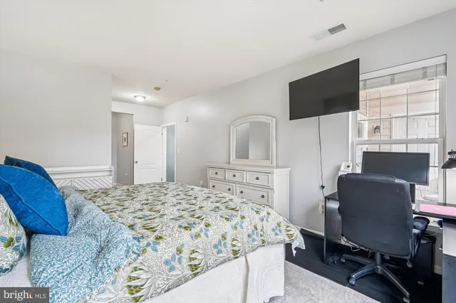 a bedroom with a bed tv and a window