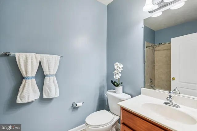 a bathroom with a sink vanity mirror and toilet
