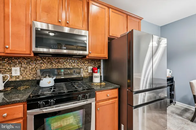 a kitchen with granite countertop a stove and a microwave