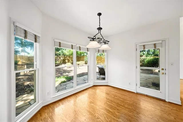 a view of empty room with wooden floor and windows