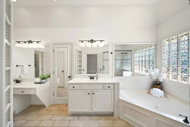 a spacious bathroom with a sink a large mirror and a bathtub