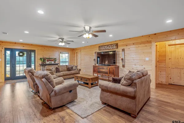 a living room with furniture ceiling fan and a flat screen tv