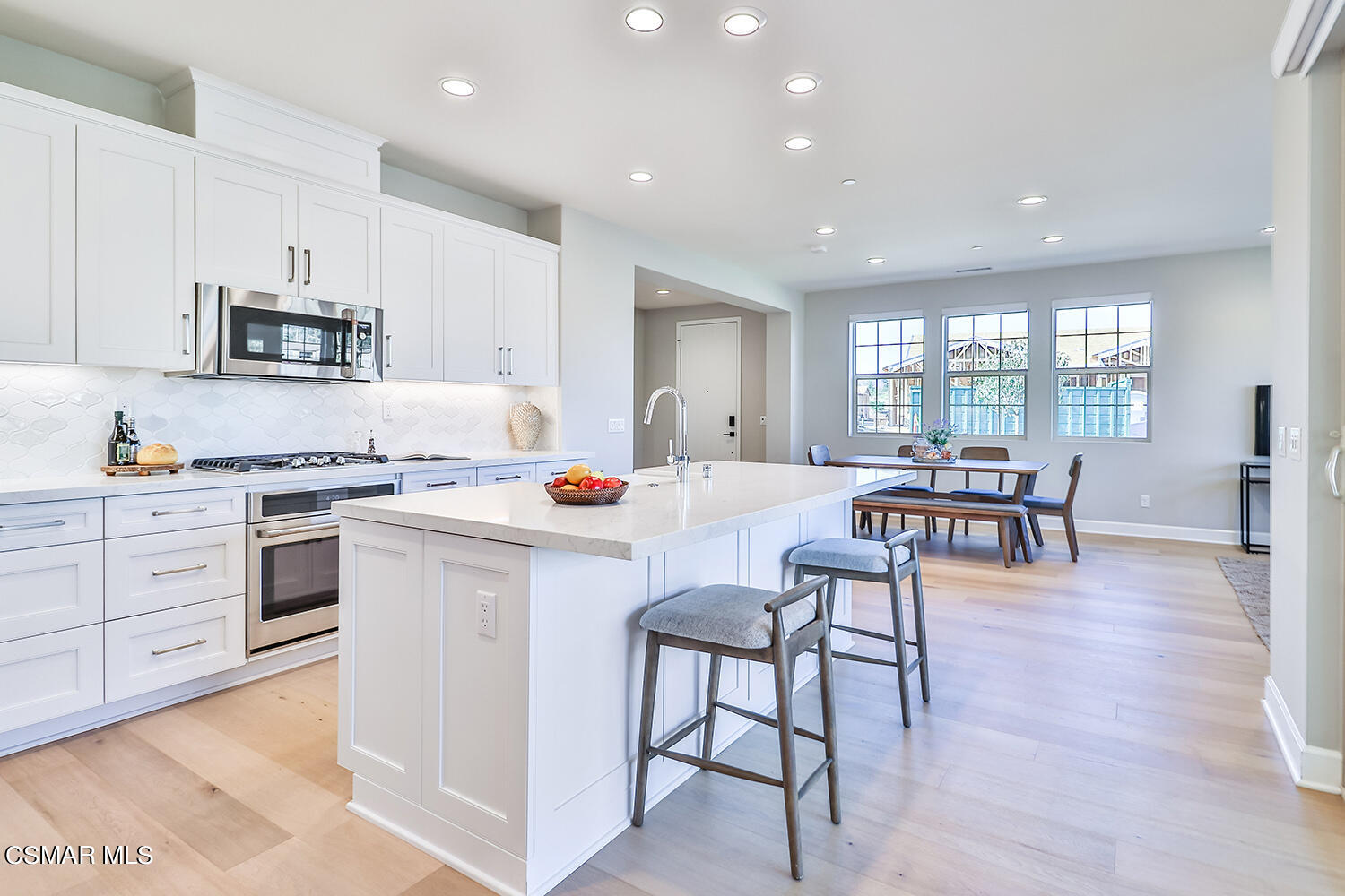 2498 Cherry Tree Drive Camarillo, CA 93012 - Photo 18 of 67 a kitchen with white cabinets and chairs