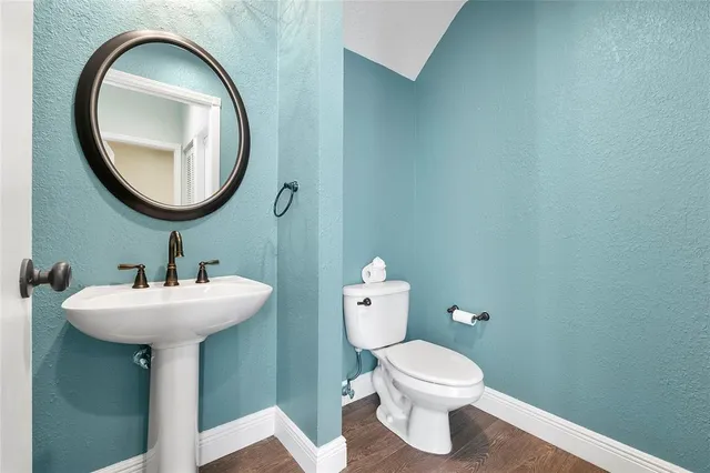 an empty room with wooden floor chandelier fan and windows