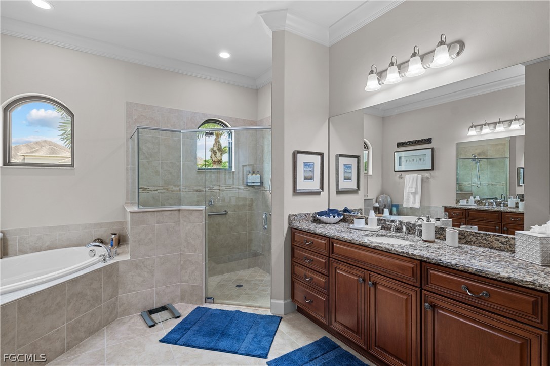 9383 Slate Court Naples, FL 34120 - Photo 14 of 28 a spacious bathroom with a granite countertop sink mirror and bathtub