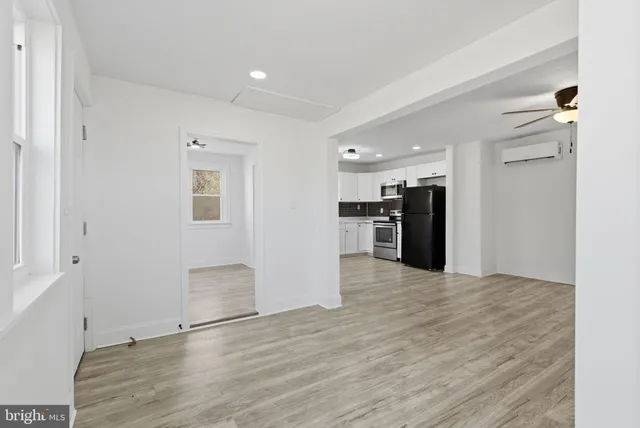 a view of kitchen with refrigerator and windows