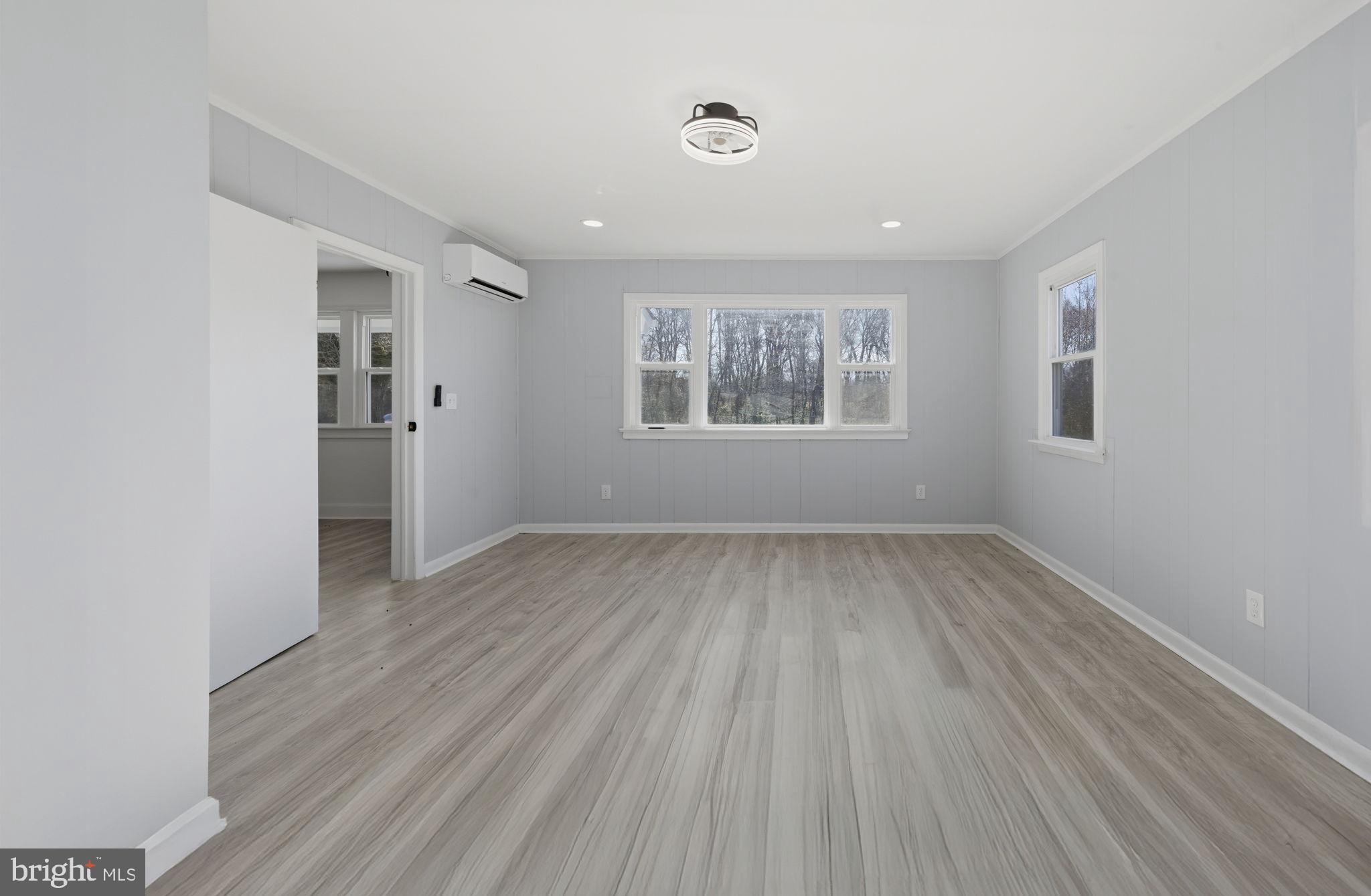 5020 Tucker Hill Road Hague, VA 22469 - Photo 30 of 31 an empty room with wooden floor and windows