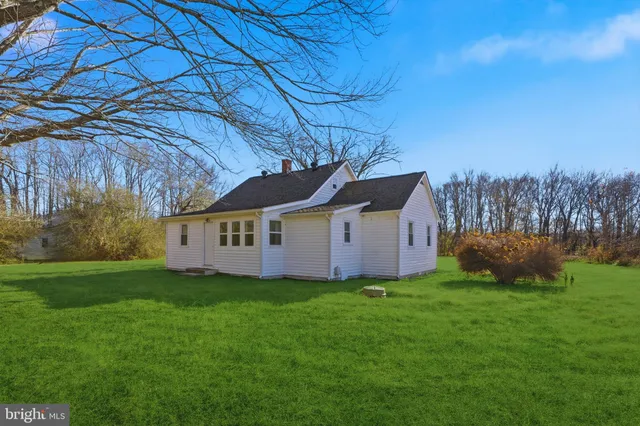 a view of a house with a yard and sitting area