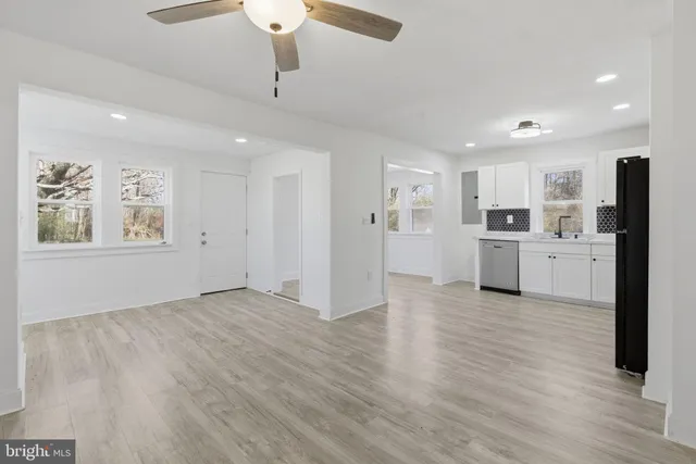 a view of a kitchen with a sink refrigerator and wooden floor