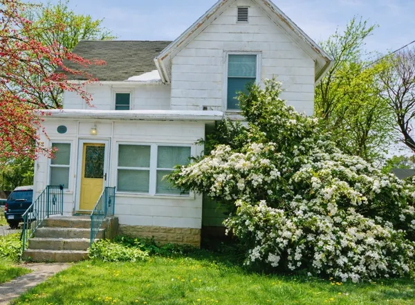 a front view of a house with a garden
