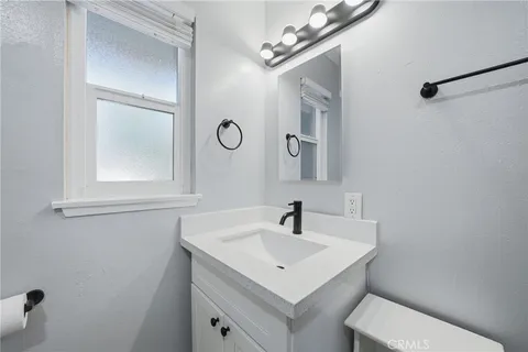 a bathroom with a sink a toilet and a mirror