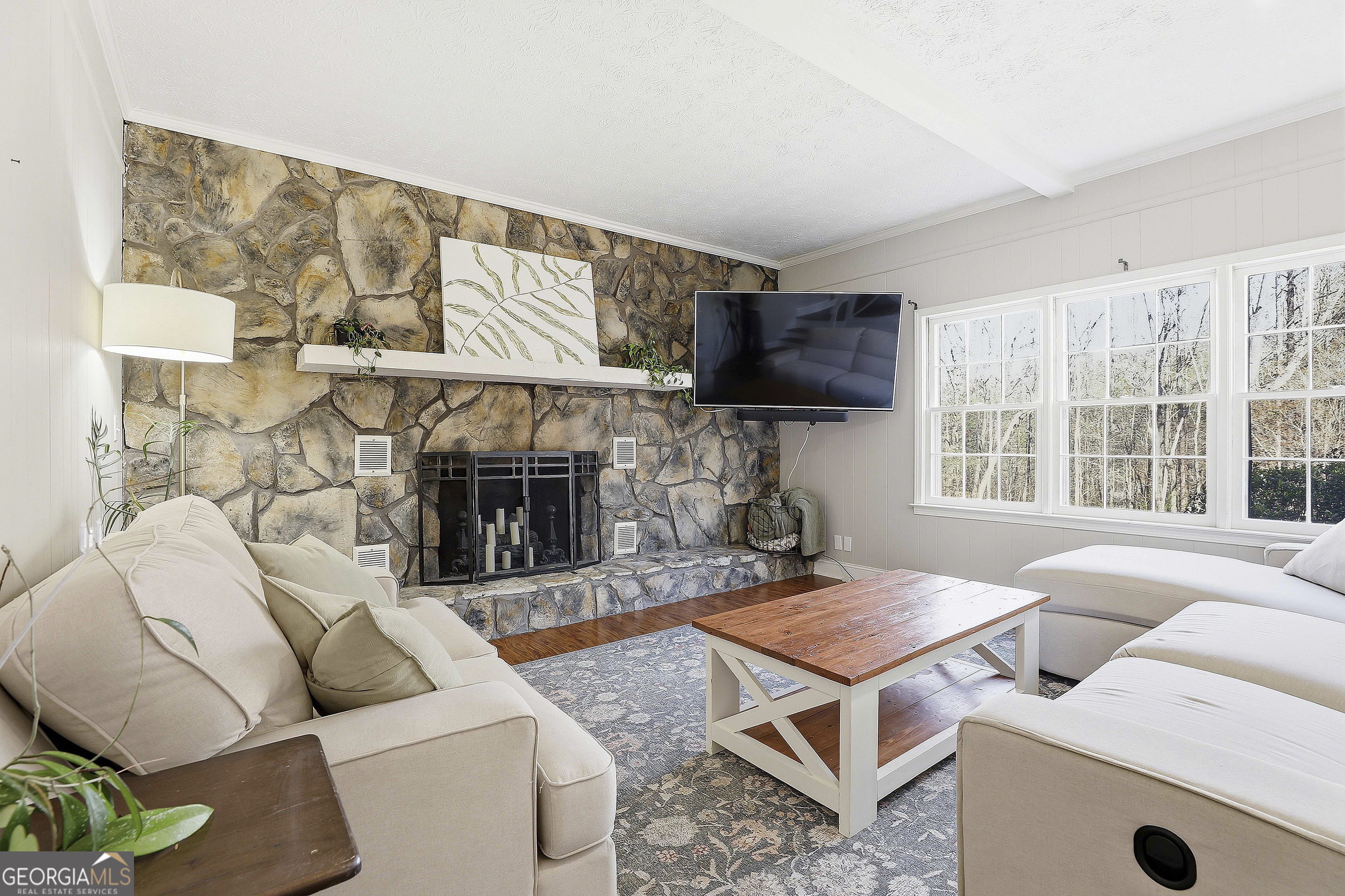 180 Lockwood Road Fayetteville, GA 30215 - Photo 21 of 59 a living room with furniture a fireplace and a flat screen tv