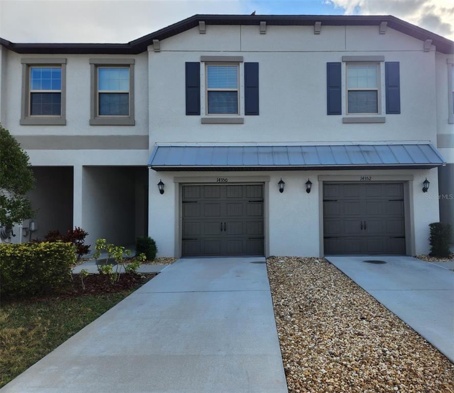 14350 Easy Goer Street Ruskin, FL 33573 - Photo 1 of 23 a front view of a house with a garden