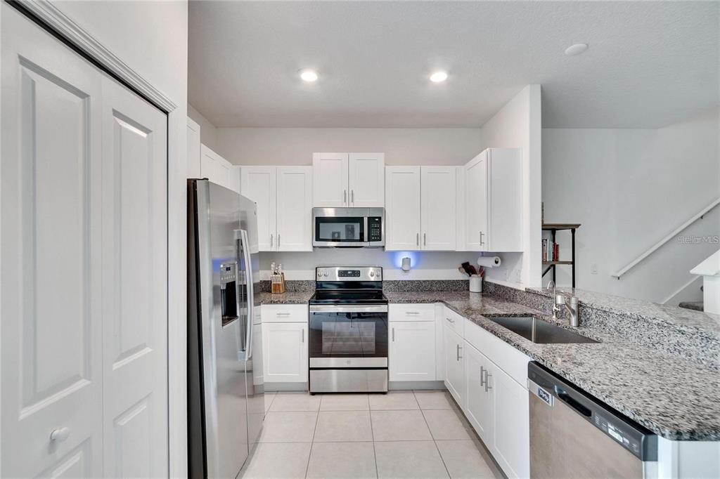 14350 Easy Goer Street Ruskin, FL 33573 - Photo 3 of 23 a kitchen with stainless steel appliances granite countertop a refrigerator and a sink