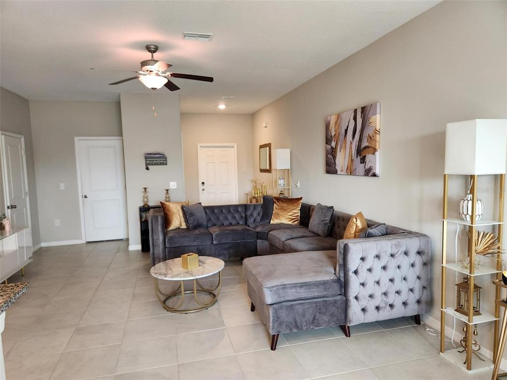14350 Easy Goer Street Ruskin, FL 33573 - Photo 8 of 23 a living room with furniture and a chandelier