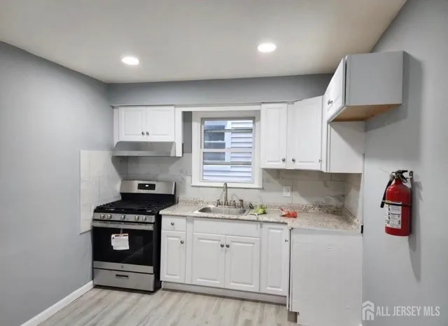 a kitchen with stainless steel appliances a stove a sink and a refrigerator