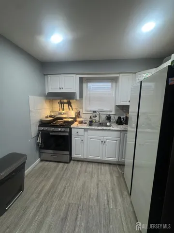 a kitchen with a refrigerator and a stove top oven