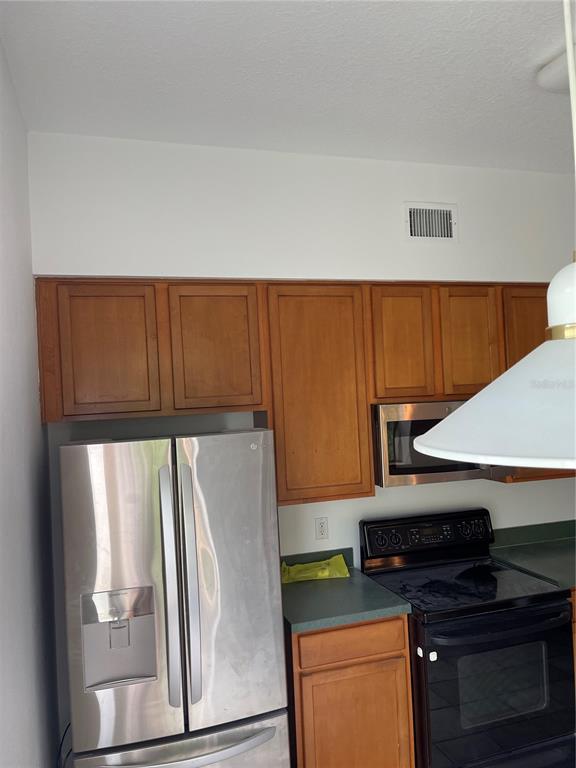 7617 Bayport Road, Unit 57 Orlando, FL 32819 - Photo 11 of 39 a kitchen with a refrigerator and a stove