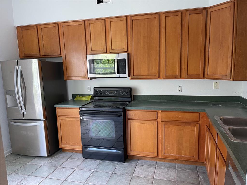 7617 Bayport Road, Unit 57 Orlando, FL 32819 - Photo 12 of 39 a kitchen with stainless steel appliances granite countertop a refrigerator sink and cabinets