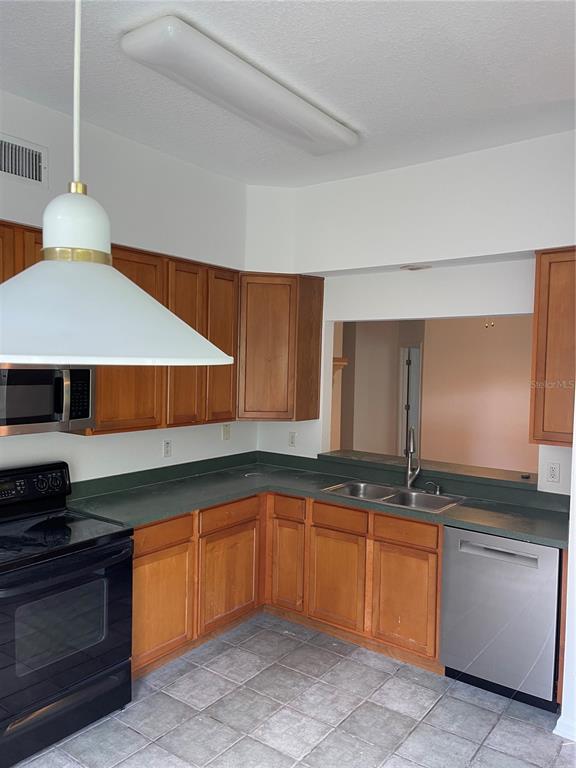 7617 Bayport Road, Unit 57 Orlando, FL 32819 - Photo 14 of 39 a kitchen with granite countertop a sink and a stove