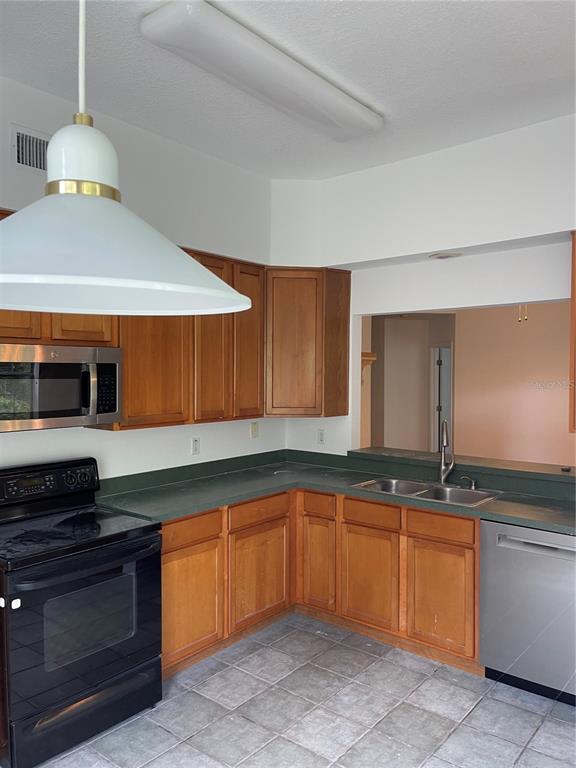7617 Bayport Road, Unit 57 Orlando, FL 32819 - Photo 15 of 39 a kitchen with granite countertop a sink and a stove