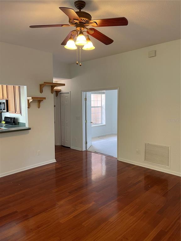 7617 Bayport Road, Unit 57 Orlando, FL 32819 - Photo 10 of 39 a view of an empty room with wooden floor and a fan