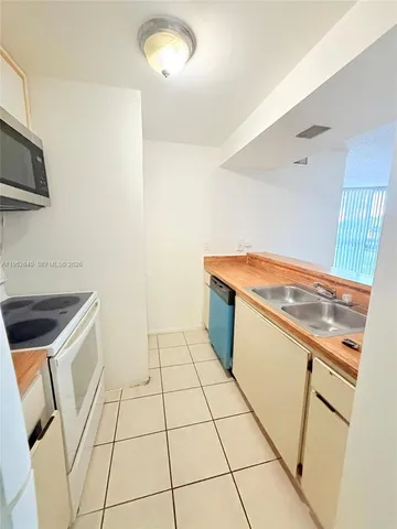 a kitchen with a sink a stove top oven and cabinets